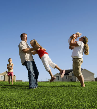 Family playing outside in the grass.